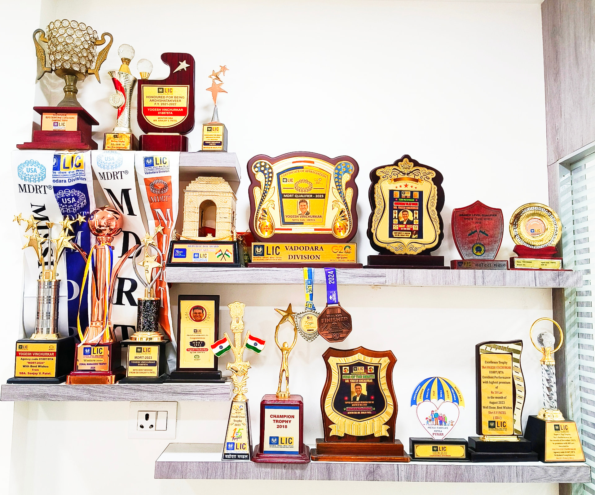 Close-up of trophies, MDRT sashes and LIC award plaques earned by Yogesh Vinchurkar