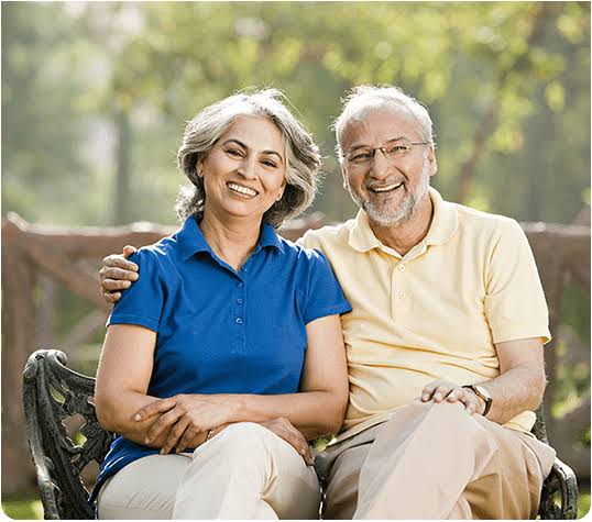 Happy retired couple sitting on a garden bench